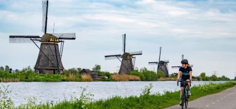 Riding along canals with windmills in the Netherlands