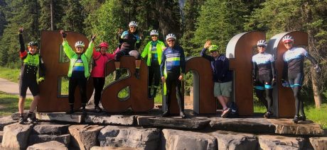 Group around the Banff park sign on Canadian Rockies bike tour