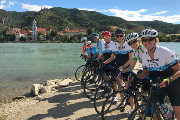 Group of cyclists by the Danube river on Prague to Vienna bike tour
