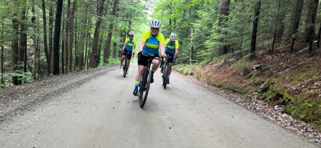 Three cyclists on a gravel road in a forest